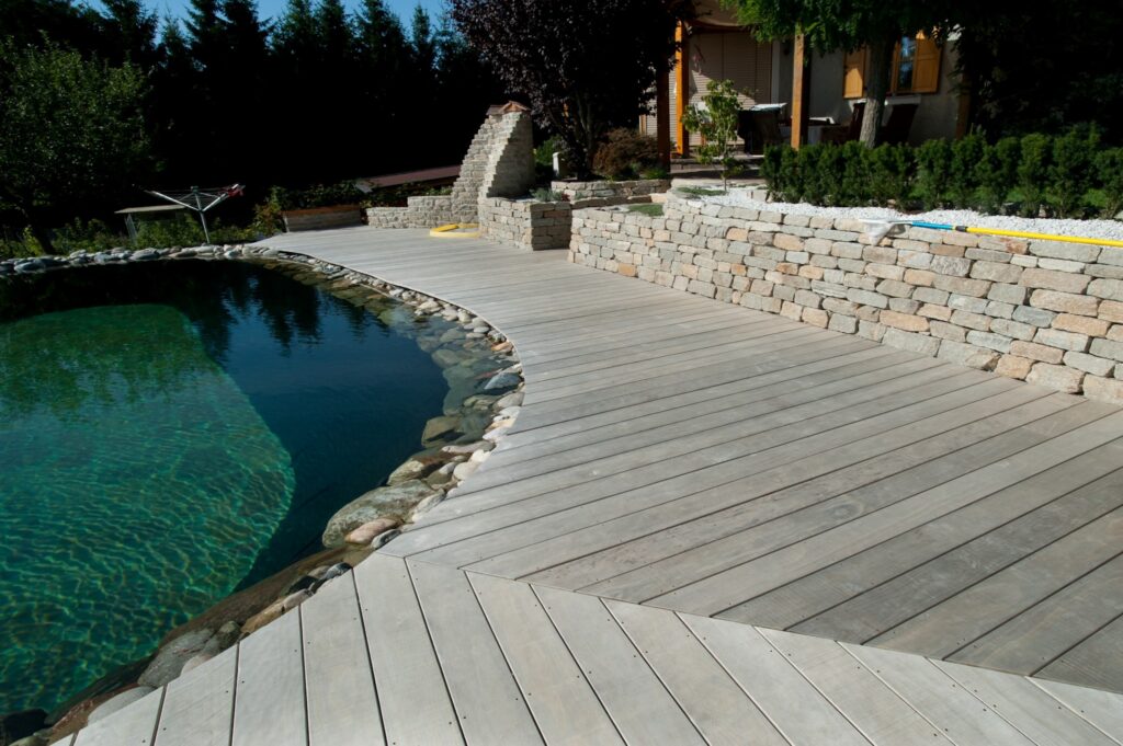 Piscine naturelle aux contours organiques avec terrasse bois Accoya