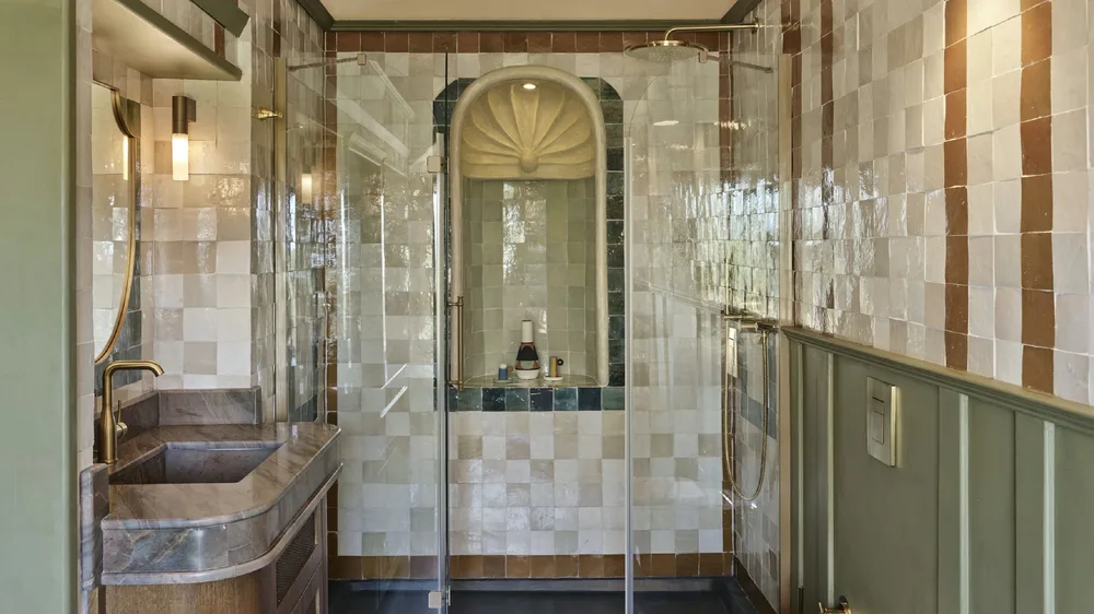 Vasque taillée dans la pierre et mur de zellige, salle de bain marocaine