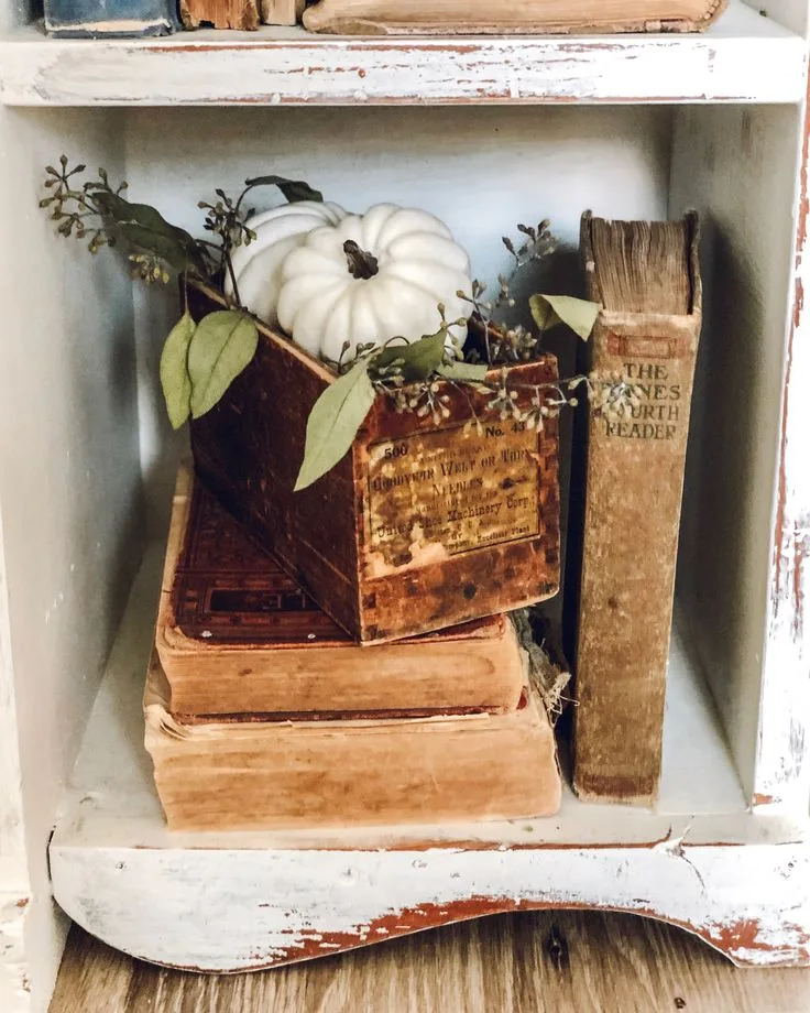 Objets chinés et courge blanche façon brocante sur une étagère