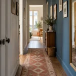 Tapis géométrique terracotta dans un couloir étroit bleu et blanc